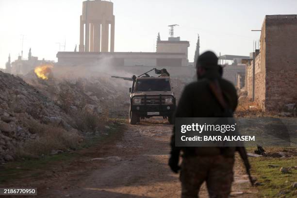 Fighters fire towards Syrian Army troops in the Rashidin district on the outskirts of Aleppo on November 29 as Hayat Tahrir al-Sham jihadists and...