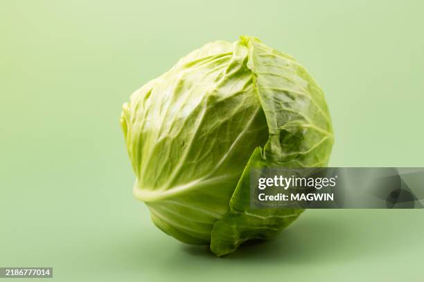 green cabbage on green background - cabbage stock pictures, royalty-free photos & images