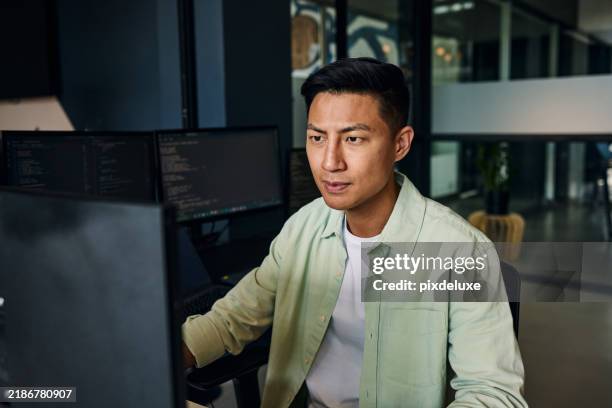 young asian man working as software developer, coding on computer in modern office - webdesigner stockfoto's en -beelden
