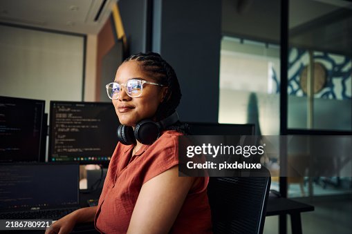 Young woman programmer focused on her work, coding on dual monitors in a modern office environment Young woman programmer focused on her work, coding on dual monitors in a modern office environment