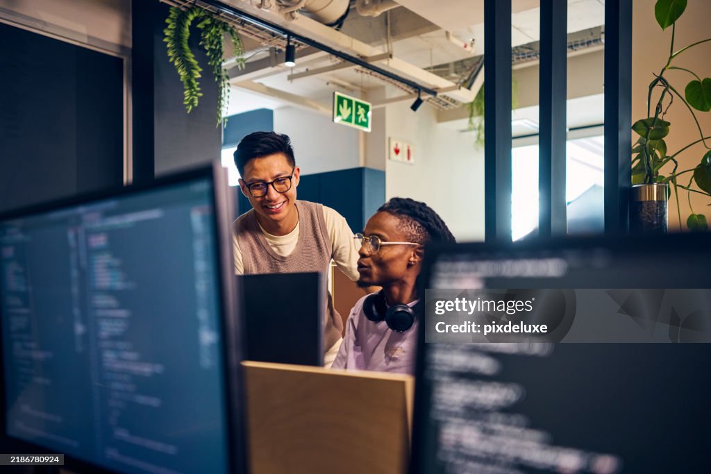Software developers working together on code in modern office
