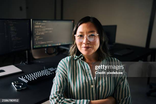 asian female programmer working on multiple computer screens in modern office - webdesigner stockfoto's en -beelden
