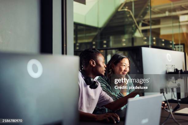 programmatori che lavorano insieme su un computer in ufficio discutendo un progetto - scoprire nuovi terreni foto e immagini stock