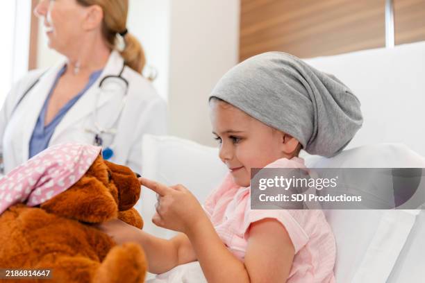 adorable little girl plays with toy while in hospital - childhood cancer stock pictures, royalty-free photos & images
