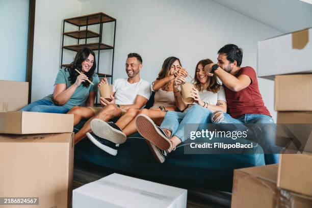 five friends are taking a lunch break during a move - roommate stock pictures, royalty-free photos & images