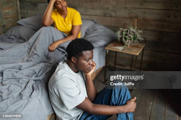 pareja de adultos jóvenes con dificultades de relación en el dormitorio - problemas de parejas fotografías e imágenes de stock