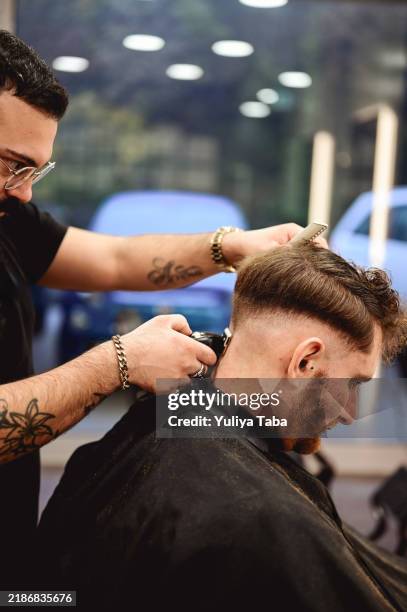 young man getting a modern haircut. - trimming beard stock pictures, royalty-free photos & images