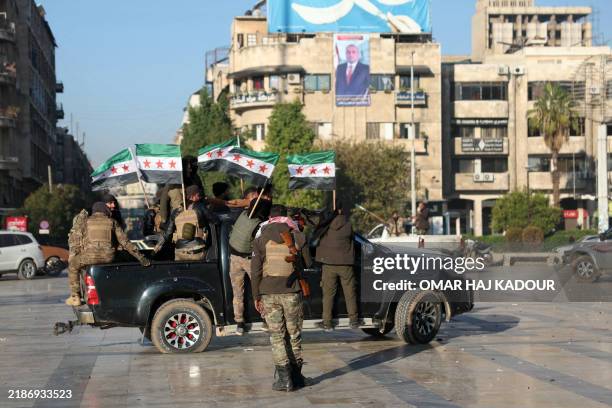 Anti-government fighters wave opposition flags in Syria's northern city of Aleppo on November 30, 2024. Jihadists and their Turkish-backed allies...
