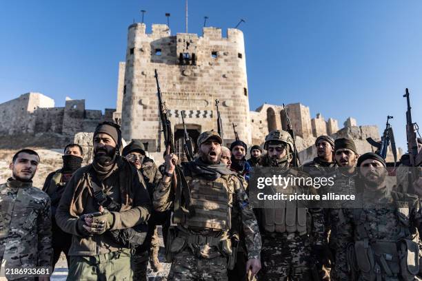 November 2024, Syria, Aleppo: Members of the Syrian armed opposition forces stand in front of the Ancient Castle of Aleppo after seizing control of...