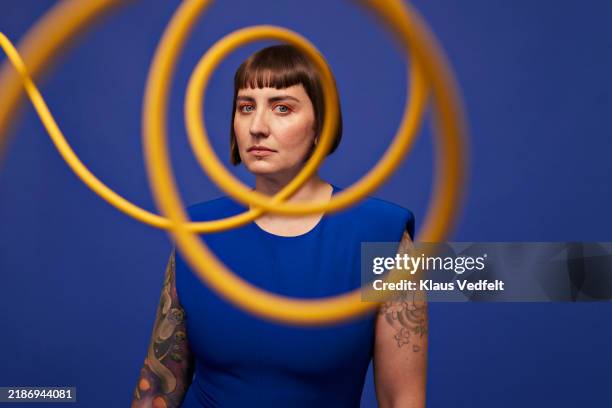 serious woman looking through spiral cables - human arm stock pictures, royalty-free photos & images