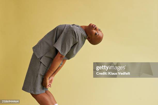 side view of non-binary person bending backwards - leaning back stock pictures, royalty-free photos & images
