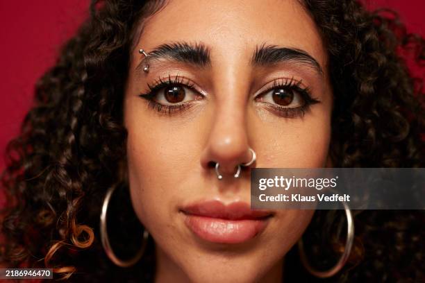 non-binary person with piercings and eye make-up - pierced stock pictures, royalty-free photos & images