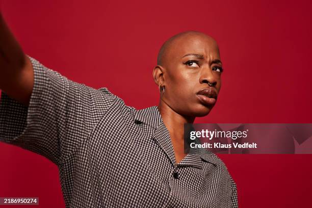 confused non-binary person with shaved head - méfiance photos et images de collection