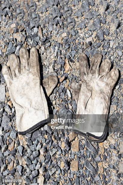 used workings gloves in the dirt - gartenhandschuh stock-fotos und bilder