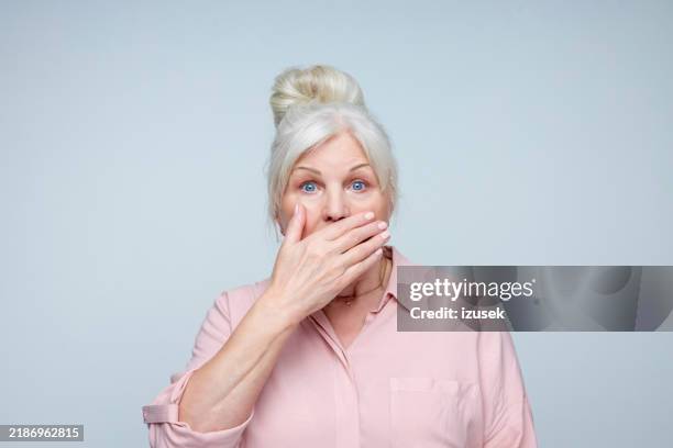 anciana aterrorizada - mano tapando la boca fotografías e imágenes de stock