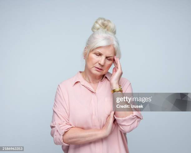 worried senior lady suffering from headache - grief stock pictures, royalty-free photos & images