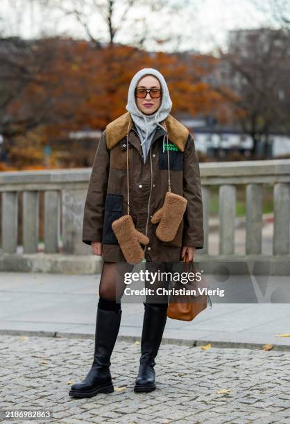 Sonia Lyson wears black Ducie London boots, Falke tights & socks, shorts Sezane, Cos pullover, Ganni x Barbour jacket, Vehla sunglasses, grey knitted...