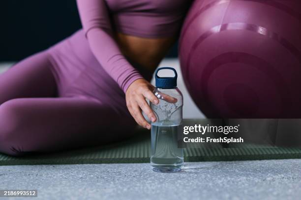 woman in activewear with water bottle and exercise ball - water bottle stock pictures, royalty-free photos & images