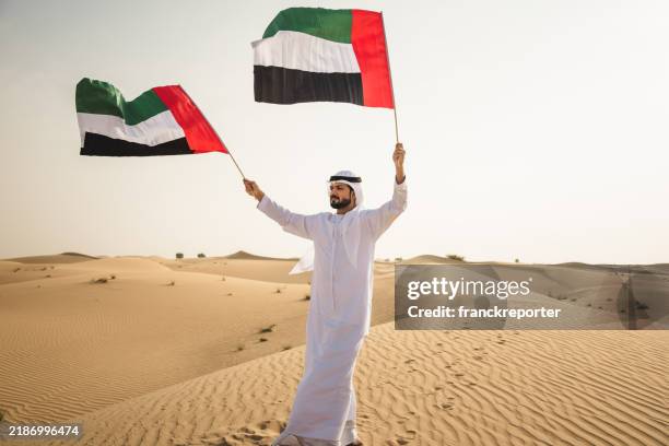 man in the desert for the uae national day - all middle eastern flags stock pictures, royalty-free photos & images