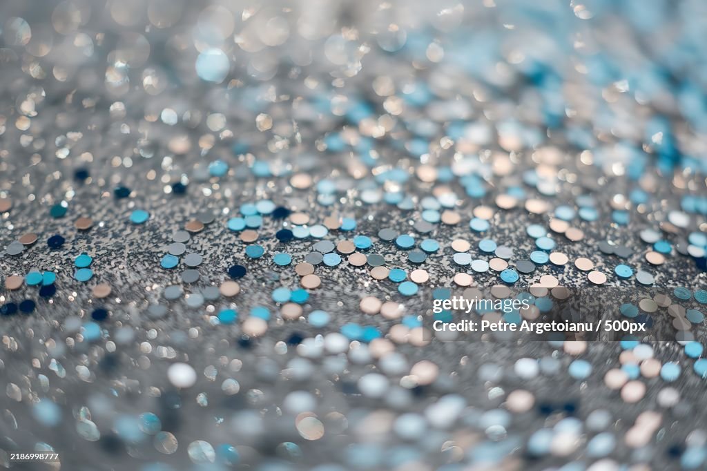 A close-up view of a glittery surface,Predominantly covered with small,Circular,And irregularly shaped sparkles