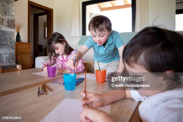 three brothers painting with watercolors in the living room - encouragement stock pictures, royalty-free photos & images