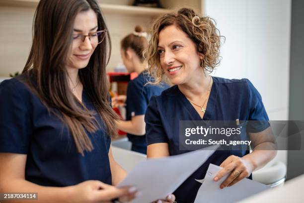 female nurses smiling during a polyclinic discussion. - effort stock pictures, royalty-free photos & images
