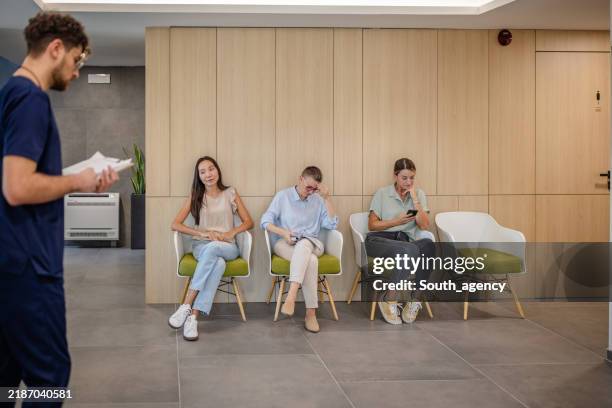 waiting room scene with three seated individuals calmly. - wachtkamer stockfoto's en -beelden