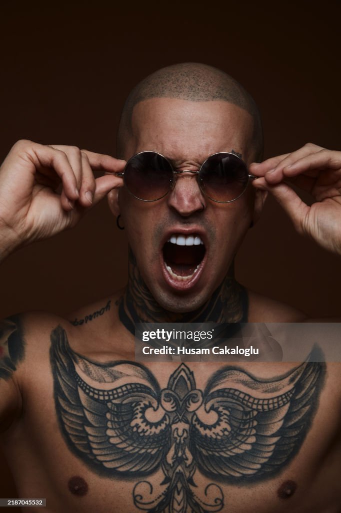 Portrait of a man in sunglasses screaming.