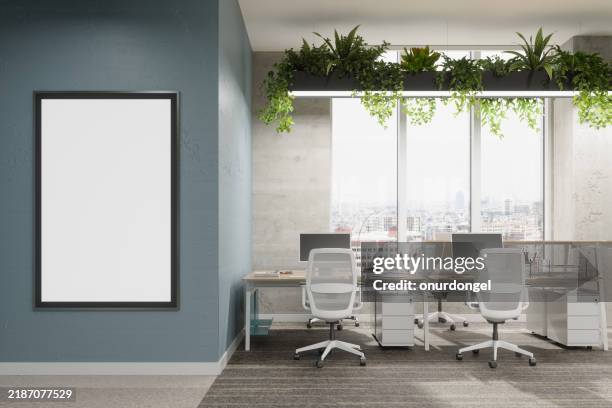 modern open plan empty office with creeper plants and close-up view of empty poster on the wall - mötesrum bildbanksfoton och bilder