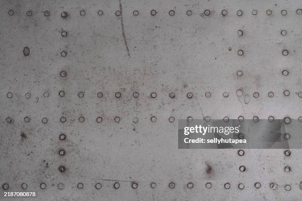 close-up of heavy metal rivets on military aircraft wing structure - nieten stock-fotos und bilder