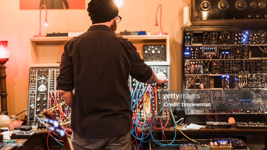 Sound Engineer and Musician with Vintage analog synth deck in sound recording studio