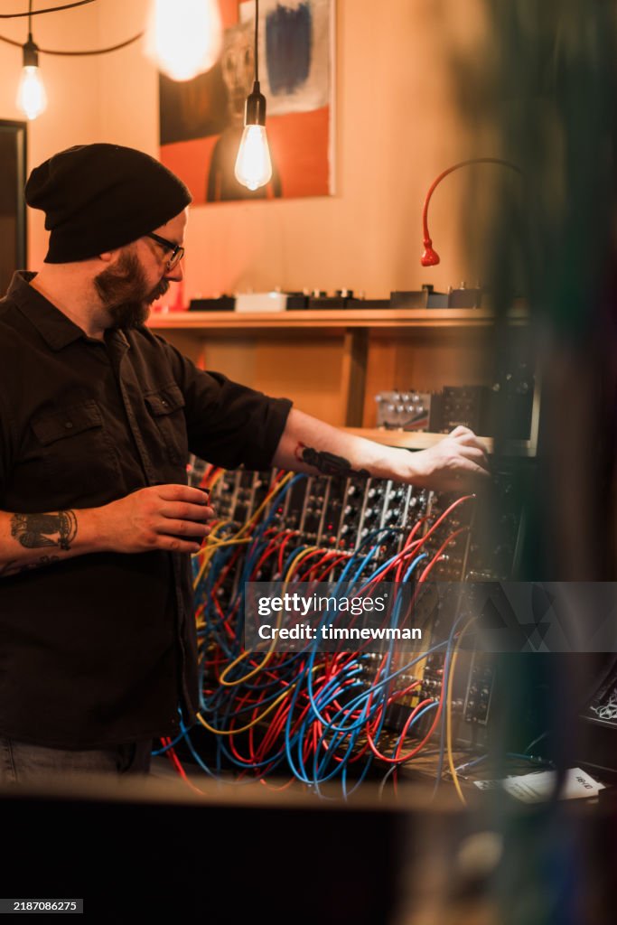 Sound Engineer and Musician with Vintage analog synth deck in sound recording studio