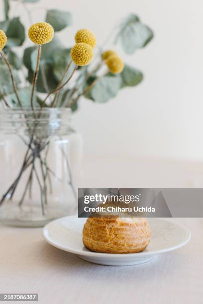 choux cream or cream puff or french profiteroles with fresh cream set on cafe table - eclair stock pictures, royalty-free photos & images