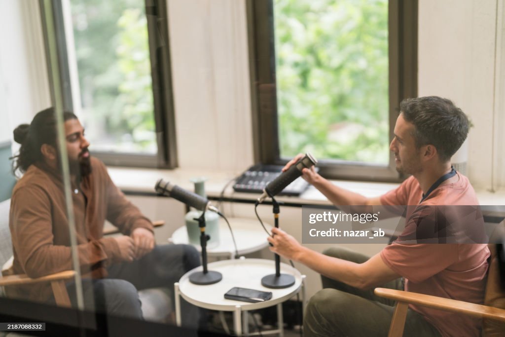 Selbstbewusste Geschäftskollegen, die einen Podcast aufnehmen.
