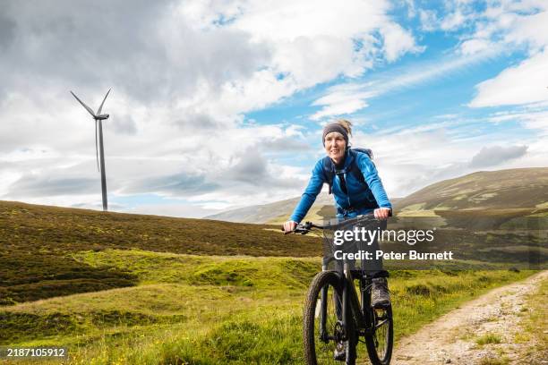 senior woman cycling at glen fiddich, moray, scotland - tough woman stock pictures, royalty-free photos & images