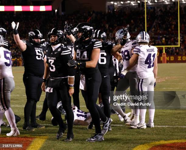 Quarterback Rocco Becht of the Iowa State Cyclones celebrates with teammates offensive lineman Brendan Black, and tight end Gabe Burkle of the Iowa...