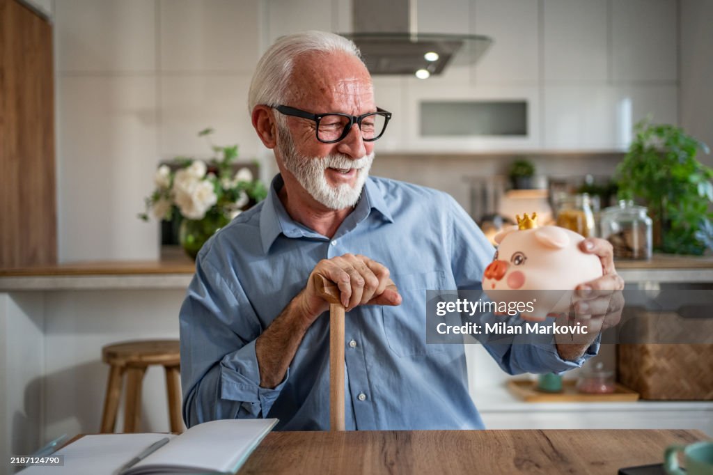 Smiling senior man holding a piggybank