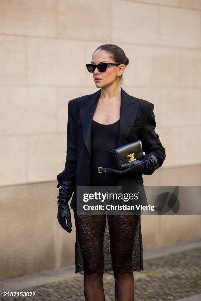 Berna Bilbey wears black bag Celine, belt Saint Laurent, sunglasses Saint Laurent, black laced skirt Mango, tailored blazer Mango, body Mango, gloves...