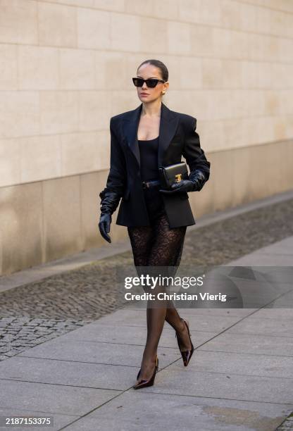 Berna Bilbey wears black bag Celine, heels Saint Laurent, belt Saint Laurent, sunglasses Saint Laurent, black laced skirt Mango, tailored blazer...