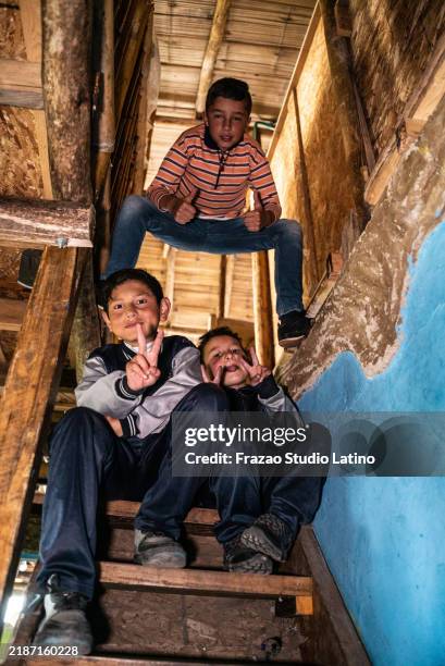 porträt eines kinderjungen, der auf der treppe eines waisenhauses sitzt - waisenhaus stock-fotos und bilder