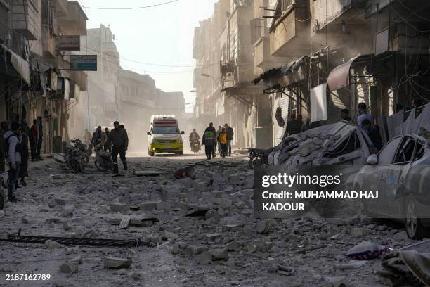 An ambulance rushes to the scene of a pro-regime forces strike that targeted a neighbourhood in Syria's rebel-held northern city of Idlib on December...