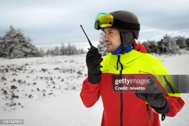 male rescue worker calling for help by using walkie talkie on the mountain - rescue worker stock pictures, royalty-free photos & images