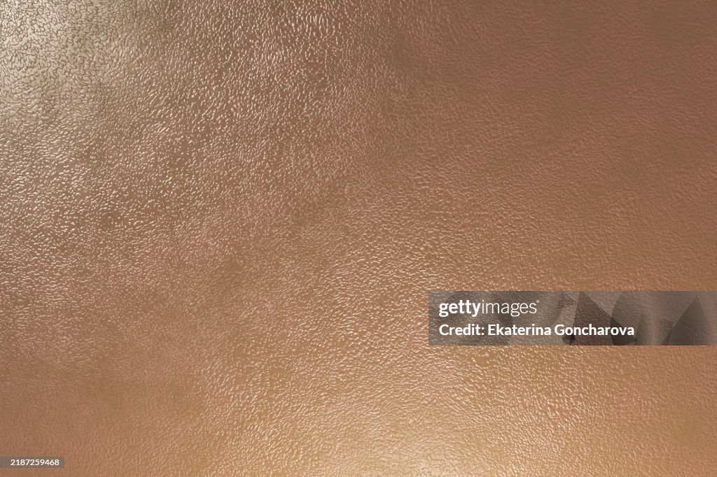 Light reflecting on textured brown vinyl surface background