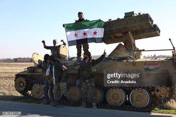 Members of the armed anti regime groups open a Syrian National Army flag as they use heavy weapons against Syrian President Bashar al-Assad's regime...