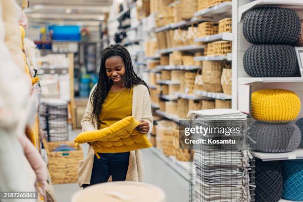 a black woman looks at chair cushions in a department store - household equipment stock pictures, royalty-free photos & images