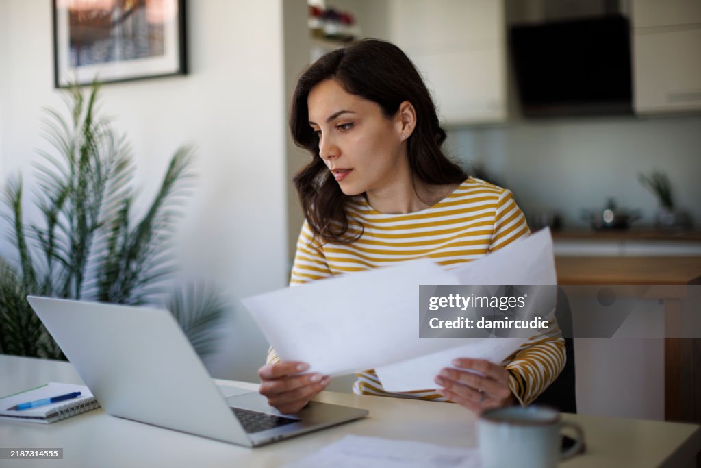 Young woman going throught her finances at home