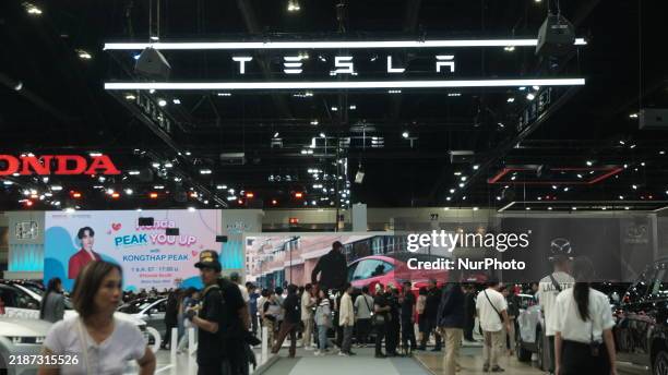 Visitors inspect Tesla cars displayed at the Thailand International Motor Expo 2024 at the IMPACT exhibition center in Bangkok, Thailand, on November...