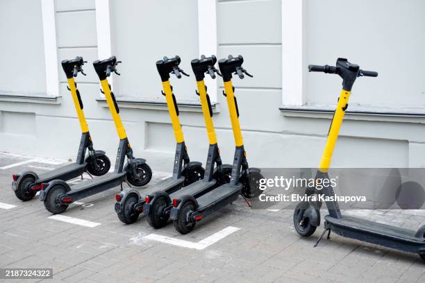 yellow city electric scooters in the parking lot - trotinete imagens e fotografias de stock