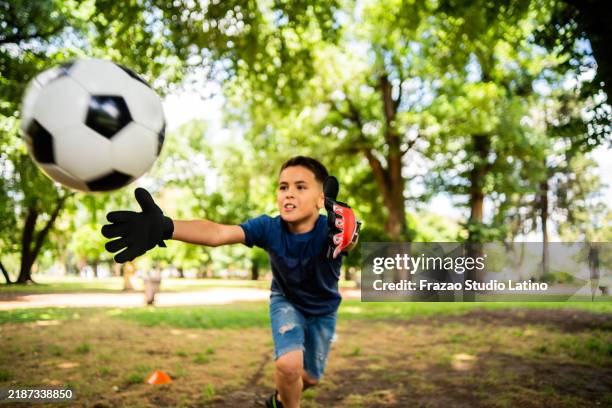 boy playing soccer on the public park - luva de guarda redes imagens e fotografias de stock