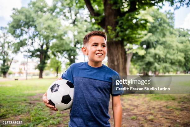 child boy holding a soccer ball on the public park - one boy only stock pictures, royalty-free photos & images